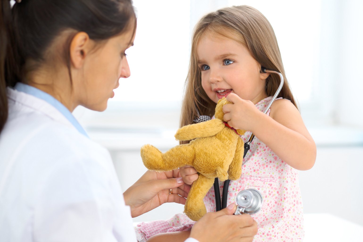 Happy little girl at  health exam at doctor office. Medicine and health care concept